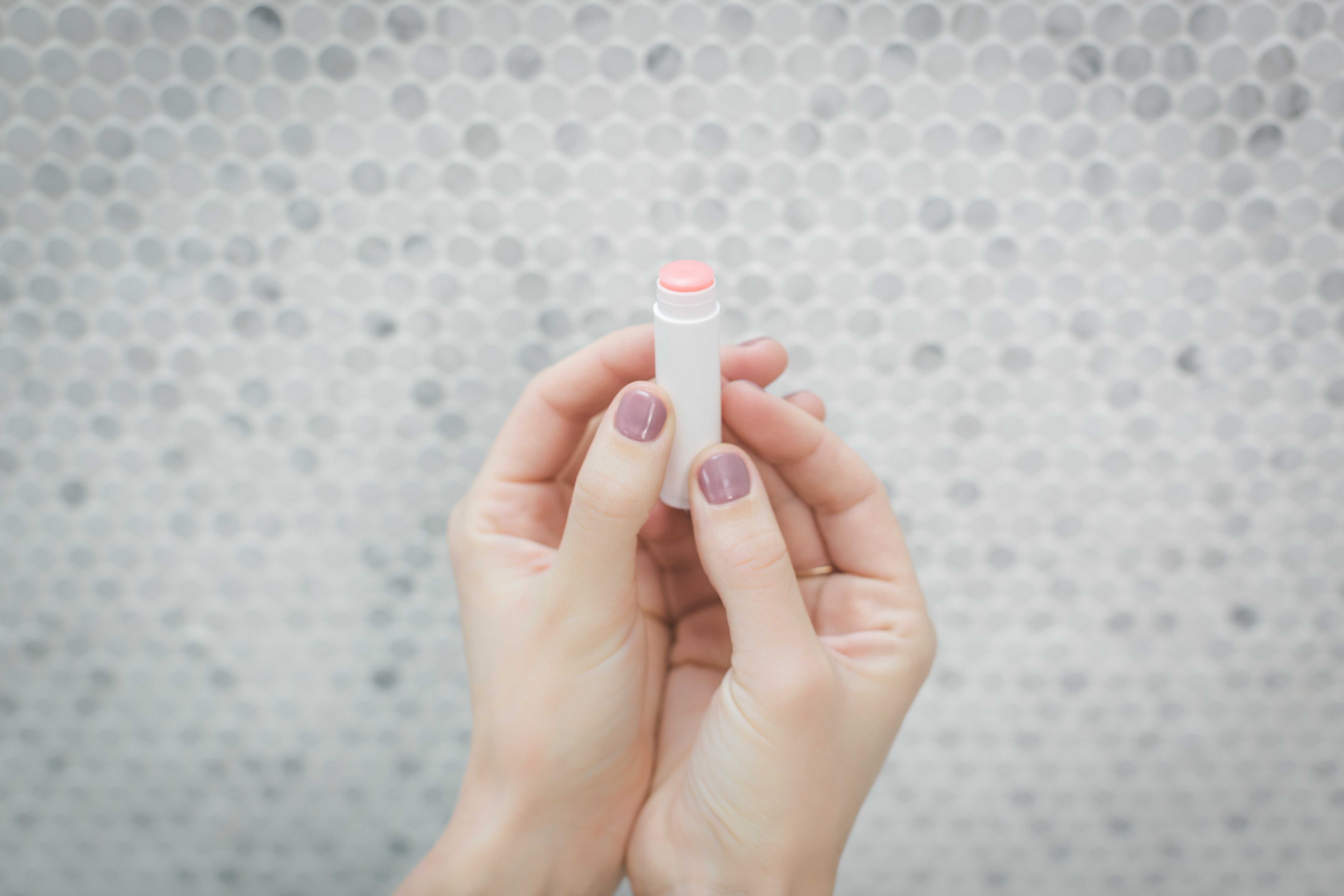 hands holding lip balm